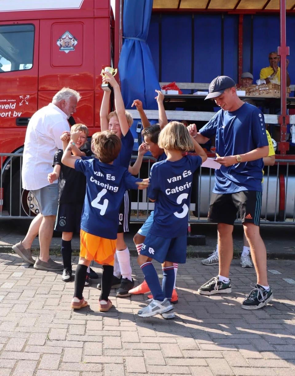 De winnaars van 7 t/m 9 jaar in blauwe shirts van van Es Catering met de beker